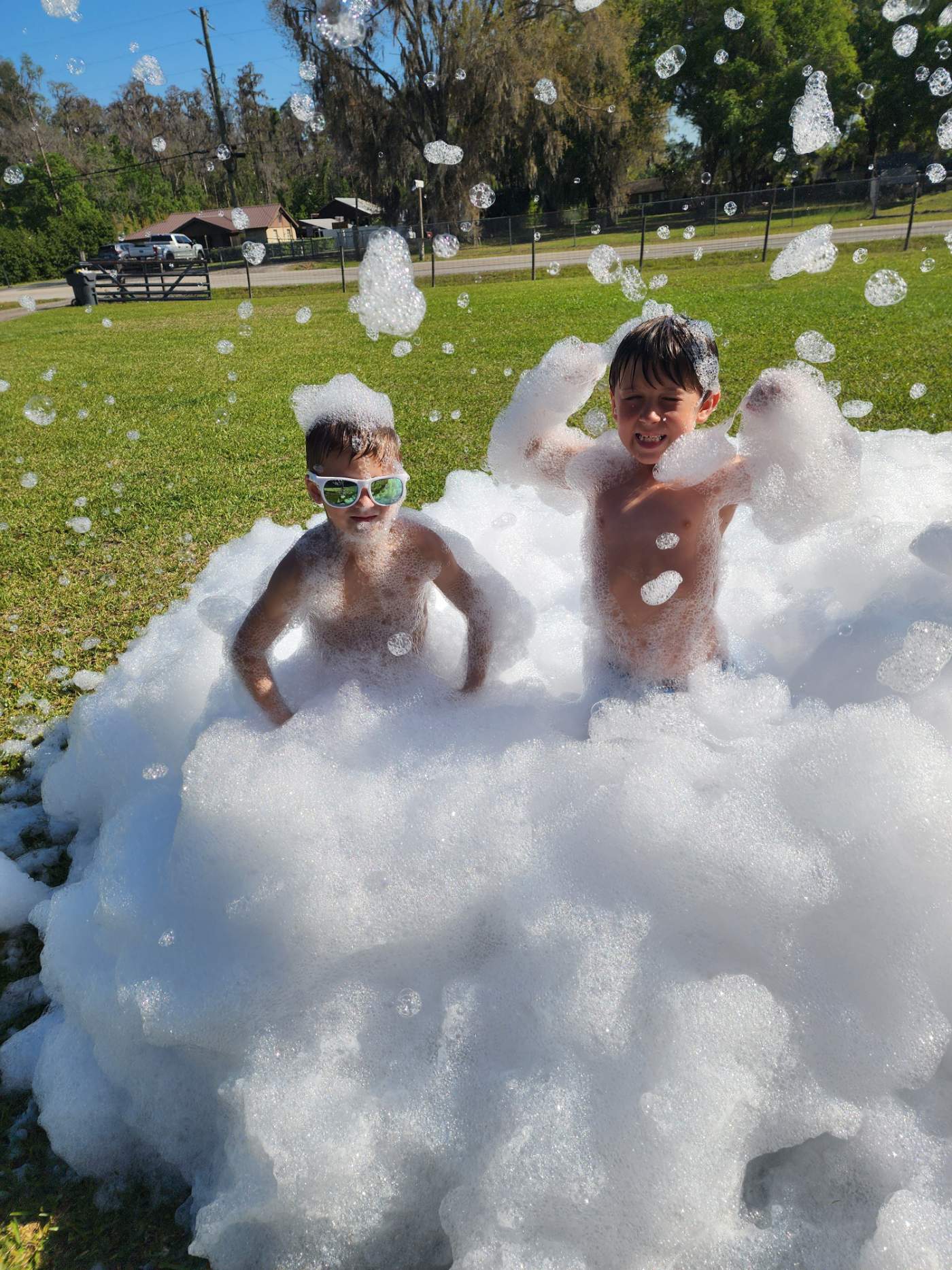 Two kids enjoying a foam pit at an outdoor party in Polk County